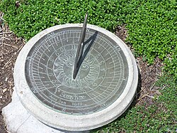 Relógio de sol projetando sombra em superfície marcada